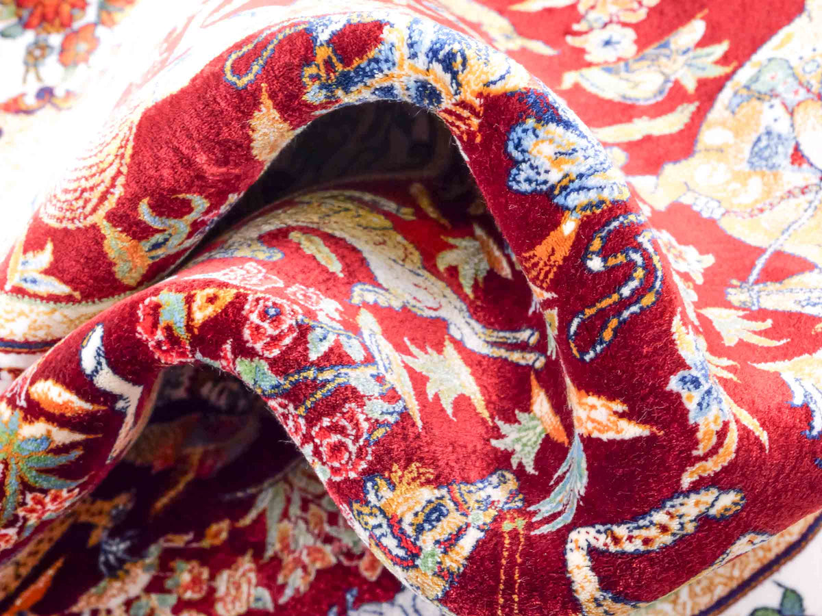 Ghom Maschinenteppich "Fariborz" 90 x 60 cm, mit Jagdmotiv, Rot-Beige, aus pflanzlicher Seide (Viskose), Hand-Finished. Teppichnummer: V25RB054H. Persian Luxury Collection by Khademi. Made in Iran / Persia – Vertrieb durch JUPITER Intl.