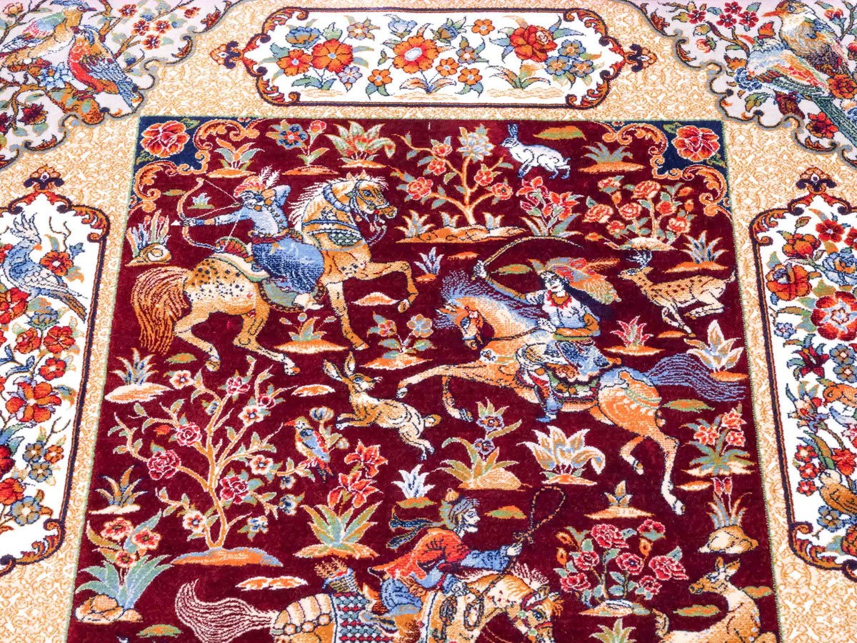 Ghom Maschinenteppich "Fariborz" 90 x 60 cm, mit Jagdmotiv, Rot-Beige, aus pflanzlicher Seide (Viskose), Hand-Finished. Teppichnummer: V25RB054H. Persian Luxury Collection by Khademi. Made in Iran / Persia – Vertrieb durch JUPITER Intl.