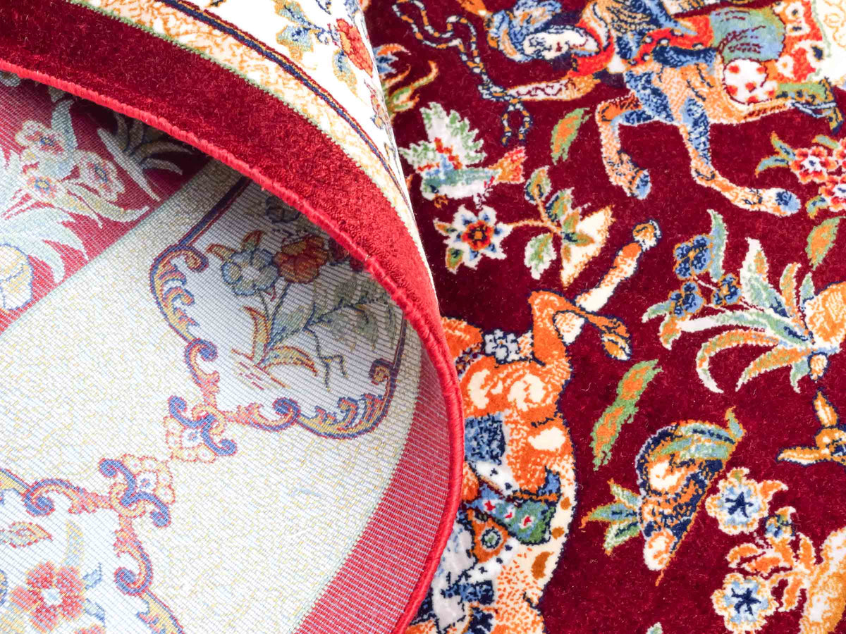 Ghom Maschinenteppich "Fariborz" 90 x 60 cm, mit Jagdmotiv, Rot-Beige, aus pflanzlicher Seide (Viskose), Hand-Finished. Teppichnummer: V25RB054H. Persian Luxury Collection by Khademi. Made in Iran / Persia – Vertrieb durch JUPITER Intl.