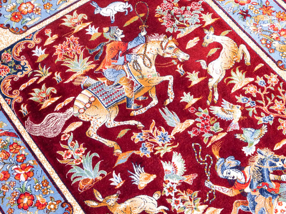 Ghom Maschinenteppich "Fariborz" 90 x 60 cm, mit Jagdmotiv, Rot-Blau, aus pflanzlicher Seide (Viskose), Hand-Finished. Teppichnummer: V25RL054H. Persian Luxury Collection by Khademi. Made in Iran / Persia – Vertrieb durch JUPITER Intl.