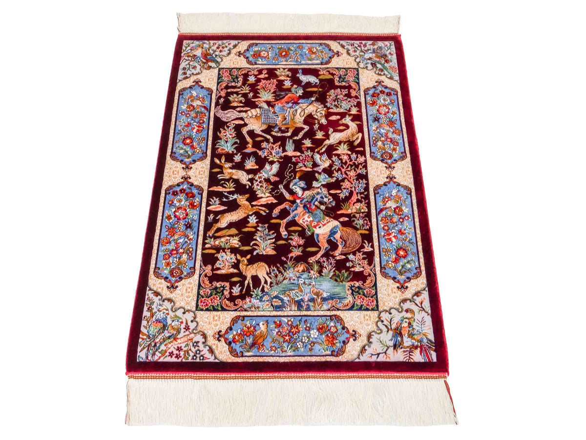 Ghom Maschinenteppich "Fariborz" 90 x 60 cm, mit Jagdmotiv, Rot-Blau, aus pflanzlicher Seide (Viskose), Hand-Finished. Teppichnummer: V25RL054H. Persian Luxury Collection by Khademi. Made in Iran / Persia – Vertrieb durch JUPITER Intl.