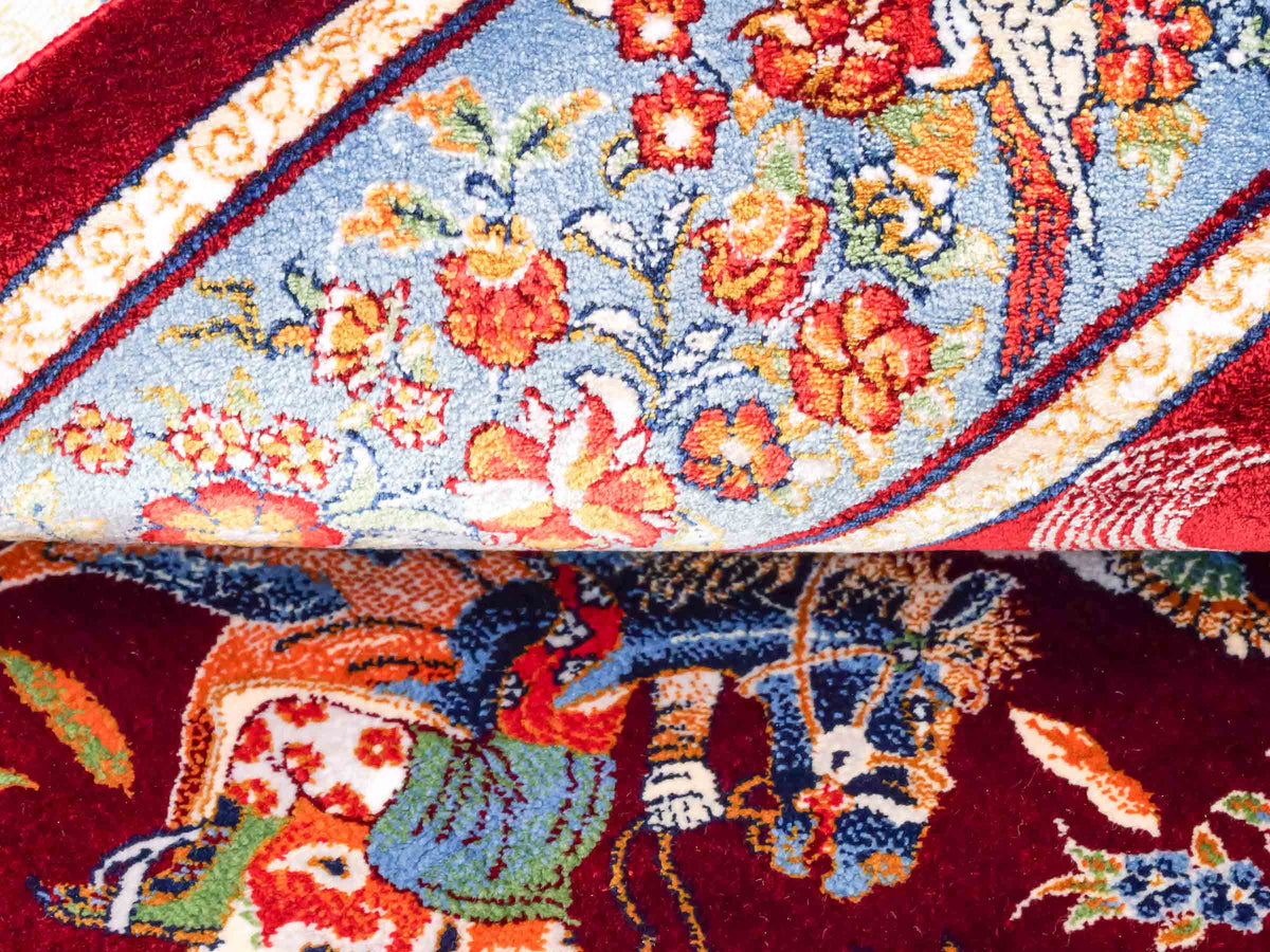 Ghom Maschinenteppich "Fariborz" 90 x 60 cm, mit Jagdmotiv, Rot-Blau, aus pflanzlicher Seide (Viskose), Hand-Finished. Teppichnummer: V25RL054H. Persian Luxury Collection by Khademi. Made in Iran / Persia – Vertrieb durch JUPITER Intl.