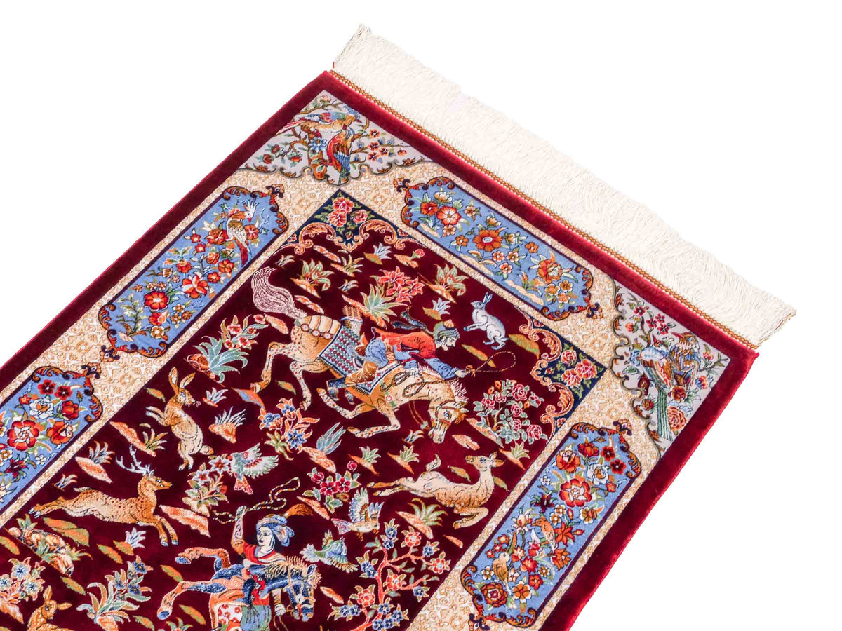 Ghom Maschinenteppich "Fariborz" 90 x 60 cm, mit Jagdmotiv, Rot-Blau, aus pflanzlicher Seide (Viskose), Hand-Finished. Teppichnummer: V25RL054H. Persian Luxury Collection by Khademi. Made in Iran / Persia – Vertrieb durch JUPITER Intl.