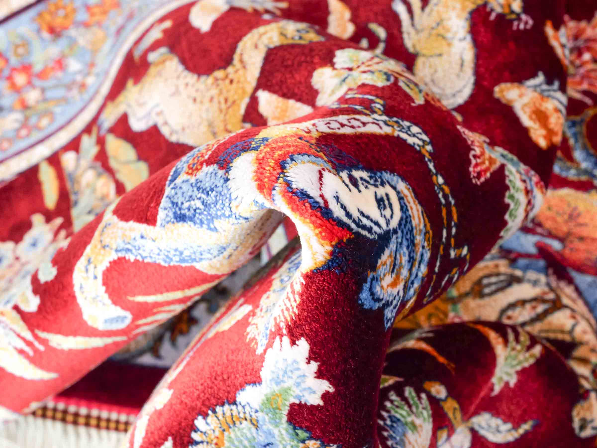 Ghom Maschinenteppich "Fariborz" 90 x 60 cm, mit Jagdmotiv, Rot-Blau, aus pflanzlicher Seide (Viskose), Hand-Finished. Teppichnummer: V25RL054H. Persian Luxury Collection by Khademi. Made in Iran / Persia – Vertrieb durch JUPITER Intl.