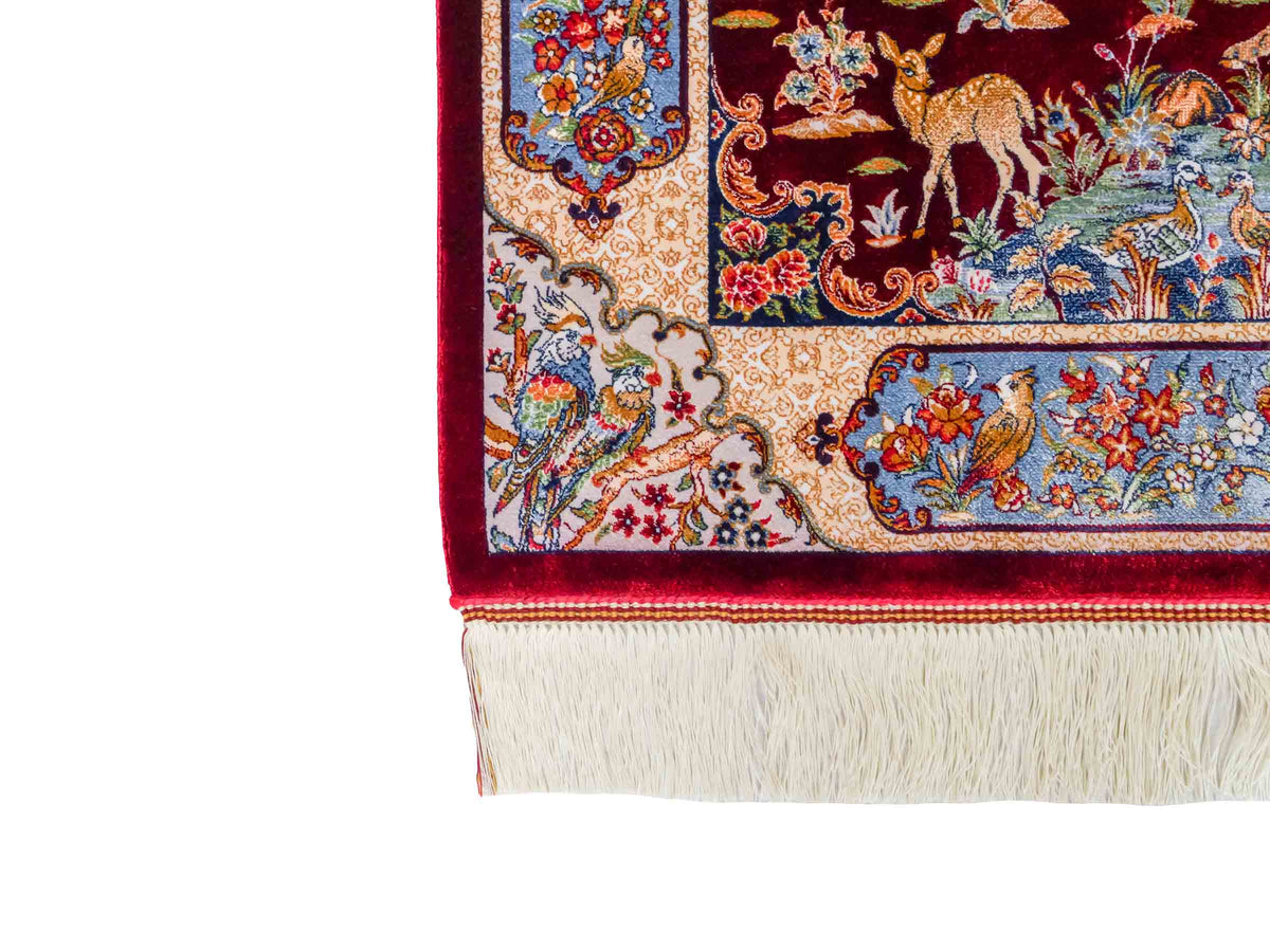 Ghom Maschinenteppich "Fariborz" 90 x 60 cm, mit Jagdmotiv, Rot-Blau, aus pflanzlicher Seide (Viskose), Hand-Finished. Teppichnummer: V25RL054H. Persian Luxury Collection by Khademi. Made in Iran / Persia – Vertrieb durch JUPITER Intl.