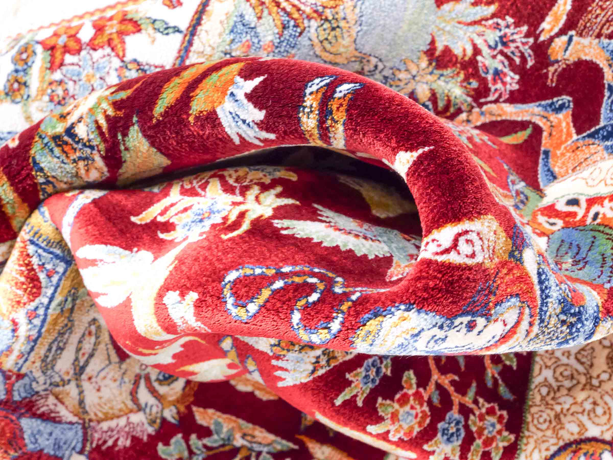 Ghom Maschinenteppich "Fariborz" 90 x 60 cm, mit Jagdmotiv, Rot, aus pflanzlicher Seide (Viskose), Hand-Finished. Teppichnummer: V25RD054H. Persian Luxury Collection by Khademi. Made in Iran / Persia – Vertrieb durch JUPITER Intl.