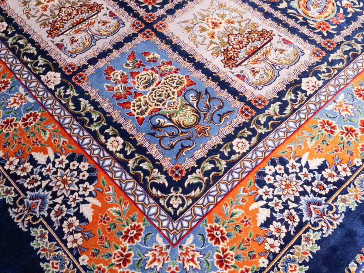 Ghom Maschinenteppich "Ferdowsi" 225 x 150 cm, mit Feldmuster, aus pflanzlicher Seide (Viskose), Marineblau/Mehrfarbig. Teppichnummer: V30NY338H. Persian Luxury Collection by Khademi. Made in Iran / Persia – Vertrieb durch JUPITER Intl.