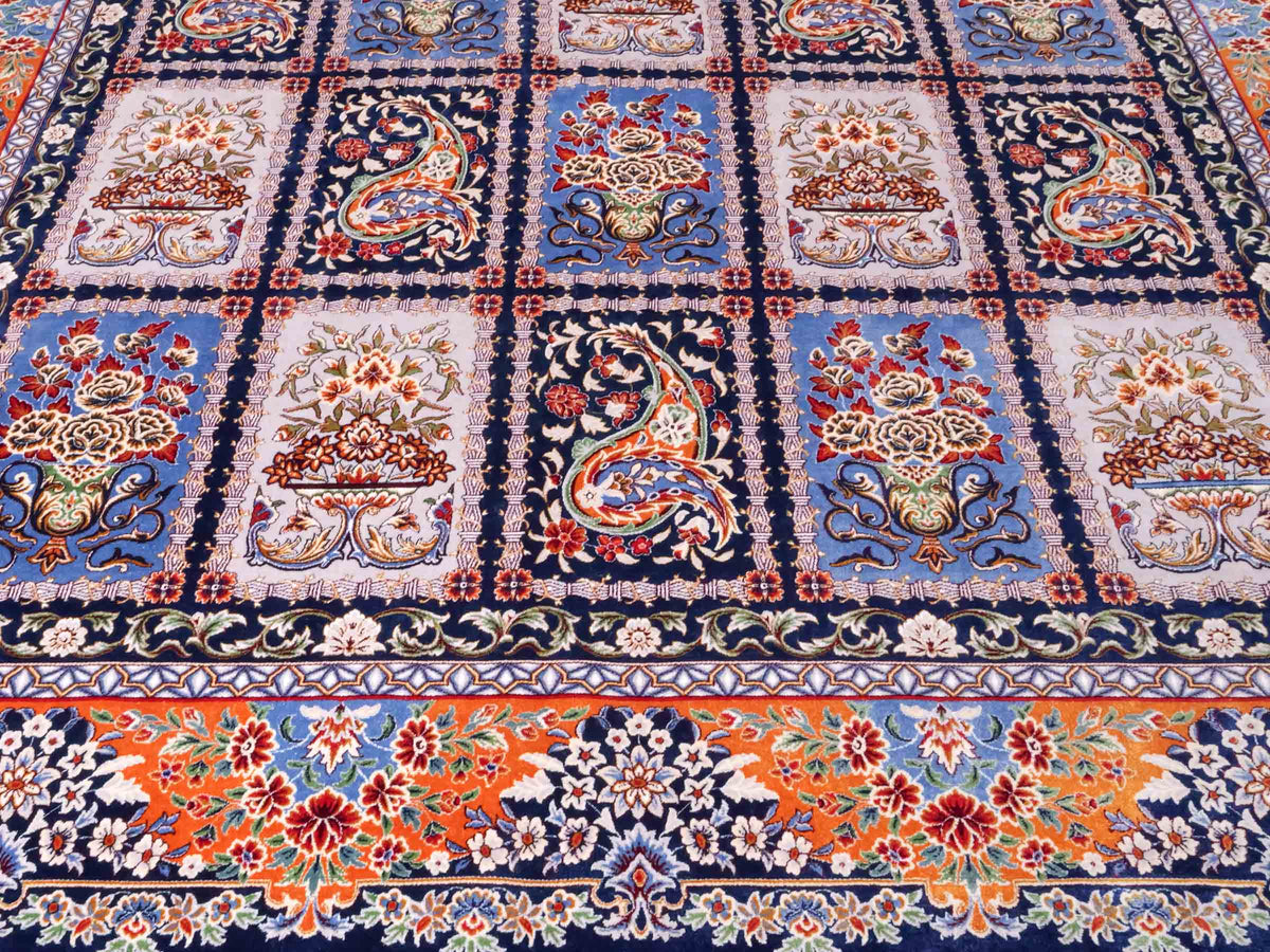 Ghom Maschinenteppich "Ferdowsi" 225 x 150 cm, mit Feldmuster, aus pflanzlicher Seide (Viskose), Marineblau/Mehrfarbig. Teppichnummer: V30NY338H. Persian Luxury Collection by Khademi. Made in Iran / Persia – Vertrieb durch JUPITER Intl.