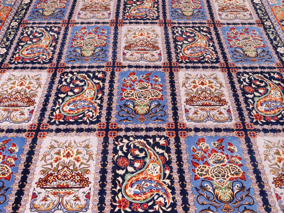 Ghom Maschinenteppich "Ferdowsi" 225 x 150 cm, mit Feldmuster, aus pflanzlicher Seide (Viskose), Marineblau/Mehrfarbig. Teppichnummer: V30NY338H. Persian Luxury Collection by Khademi. Made in Iran / Persia – Vertrieb durch JUPITER Intl.