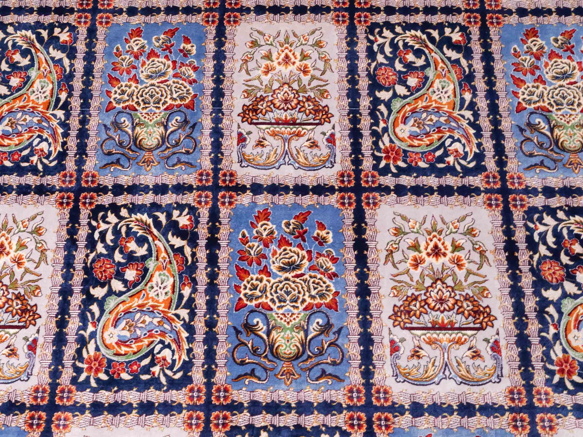 Ghom Maschinenteppich "Ferdowsi" 225 x 150 cm, mit Feldmuster, aus pflanzlicher Seide (Viskose), Marineblau/Mehrfarbig. Teppichnummer: V30NY338H. Persian Luxury Collection by Khademi. Made in Iran / Persia – Vertrieb durch JUPITER Intl.