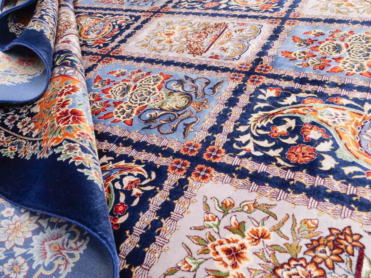 Ghom Maschinenteppich "Ferdowsi" 225 x 150 cm, mit Feldmuster, aus pflanzlicher Seide (Viskose), Marineblau/Mehrfarbig. Teppichnummer: V30NY338H. Persian Luxury Collection by Khademi. Made in Iran / Persia – Vertrieb durch JUPITER Intl.