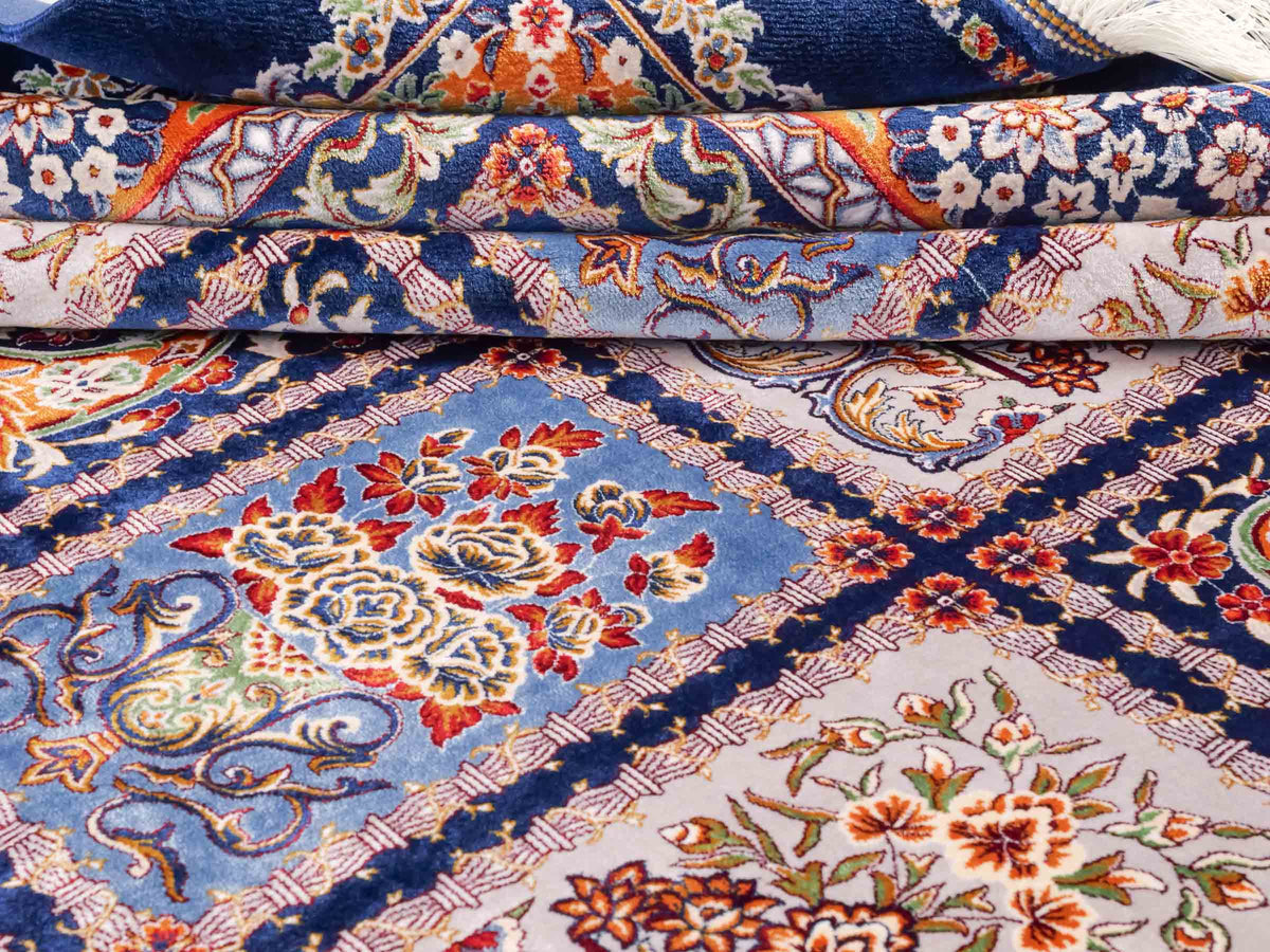 Ghom Maschinenteppich "Ferdowsi" 225 x 150 cm, mit Feldmuster, aus pflanzlicher Seide (Viskose), Marineblau/Mehrfarbig. Teppichnummer: V30NY338H. Persian Luxury Collection by Khademi. Made in Iran / Persia – Vertrieb durch JUPITER Intl.