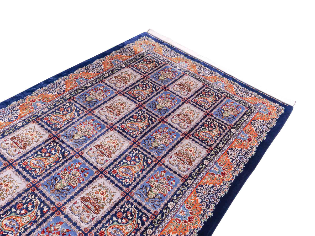 Ghom Maschinenteppich "Ferdowsi" 225 x 150 cm, mit Feldmuster, aus pflanzlicher Seide (Viskose), Marineblau/Mehrfarbig. Teppichnummer: V30NY338H. Persian Luxury Collection by Khademi. Made in Iran / Persia – Vertrieb durch JUPITER Intl.