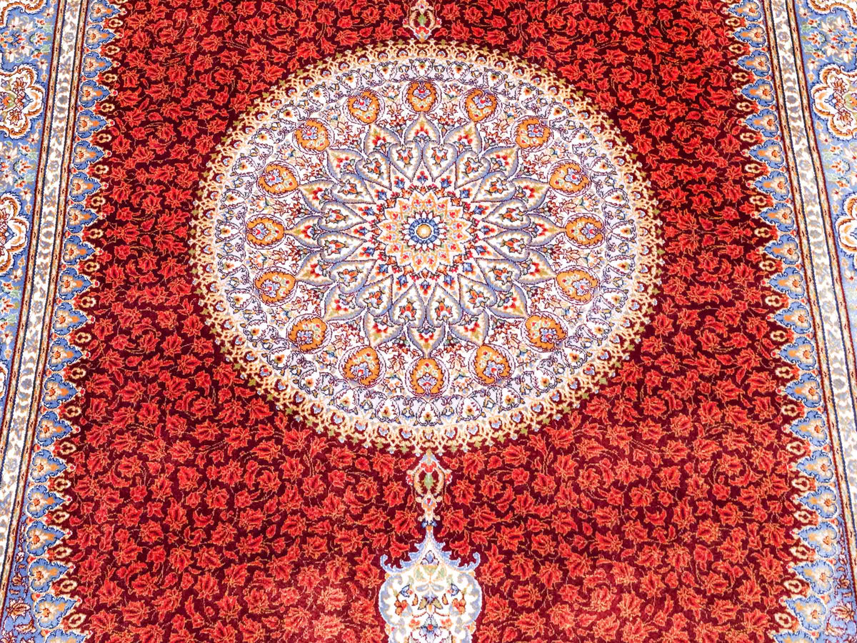 Ghom Maschinenteppich "Fereydun" 120 x 80 cm aus pflanzlicher Seide (Viskose) mit Medaillon, Rot-Orange. Teppichnummer: V28RD096M. Persian Luxury Collection by Khademi. Made in Iran / Persia – Vertrieb durch JUPITER Intl.
