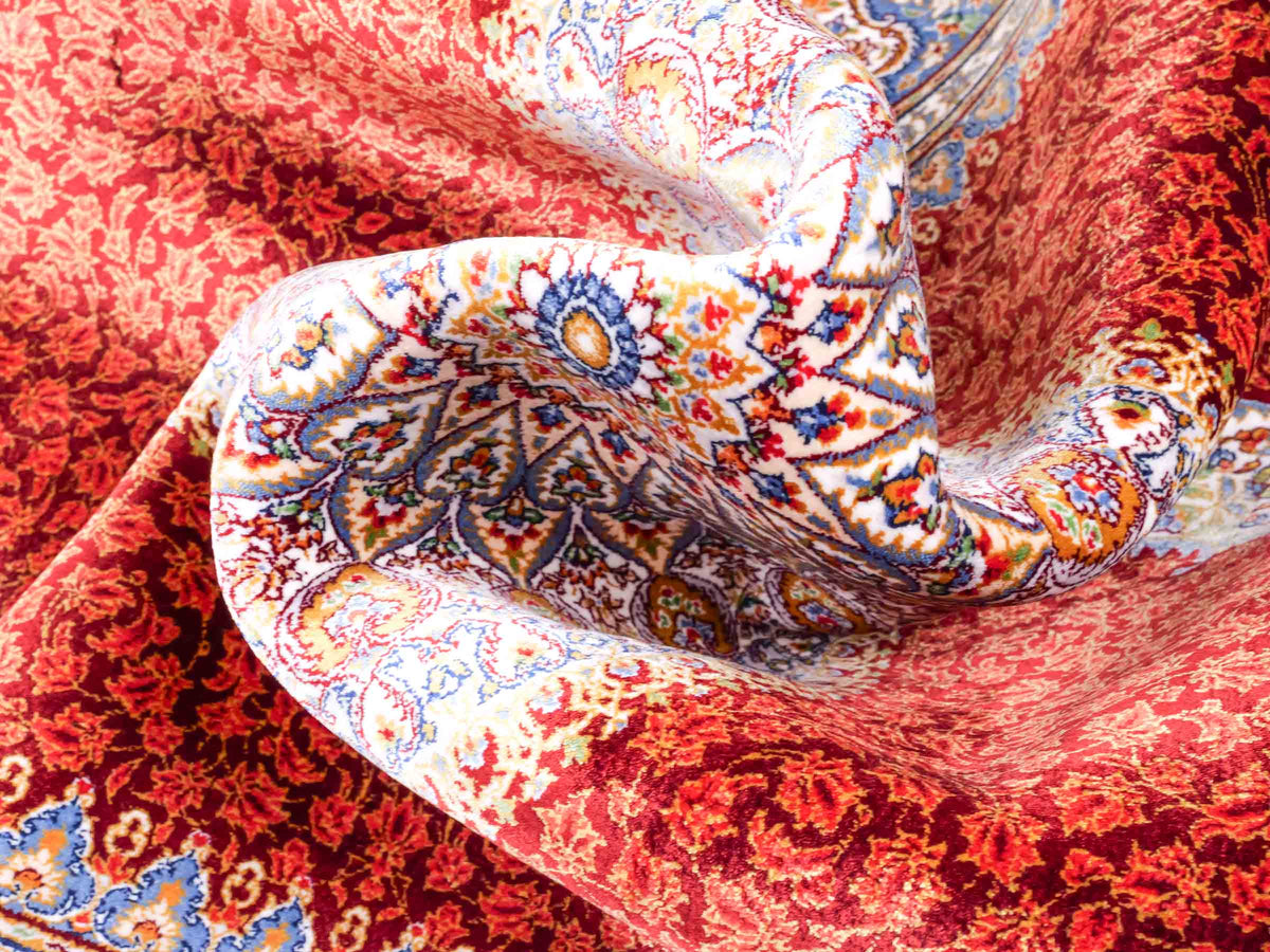 Ghom Maschinenteppich "Fereydun" 120 x 80 cm aus pflanzlicher Seide (Viskose) mit Medaillon, Rot-Orange. Teppichnummer: V28RD096M. Persian Luxury Collection by Khademi. Made in Iran / Persia – Vertrieb durch JUPITER Intl.