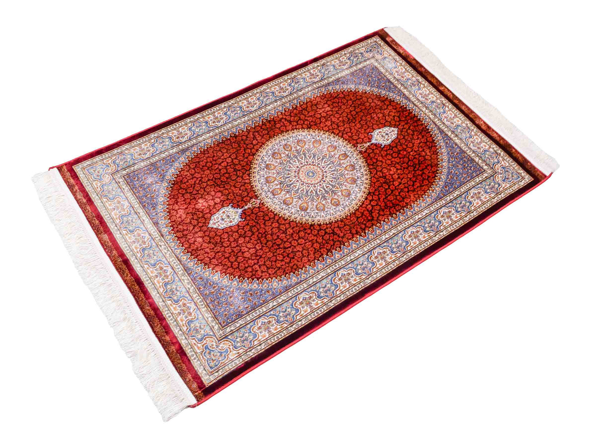Ghom Maschinenteppich "Fereydun" 120 x 80 cm aus pflanzlicher Seide (Viskose) mit Medaillon, Rot-Orange. Teppichnummer: V28RD096M. Persian Luxury Collection by Khademi. Made in Iran / Persia – Vertrieb durch JUPITER Intl.