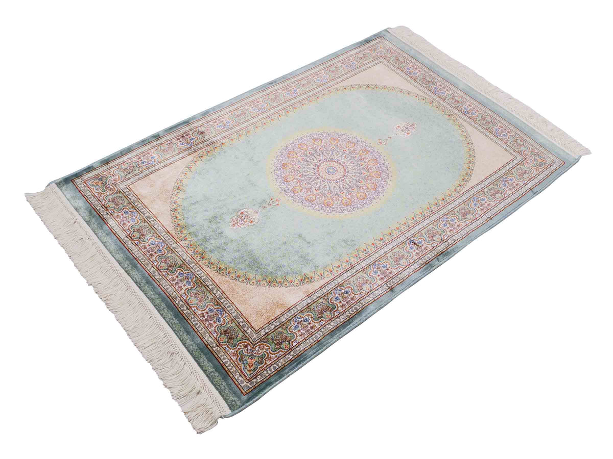 Ghom Maschinenteppich "Fereydun" 120 x 80 cm aus pflanzlicher Seide (Viskose) mit Medaillon, Türkis. Teppichnummer: V28TL096M. Persian Luxury Collection by Khademi. Made in Iran / Persia – Vertrieb durch JUPITER Intl.