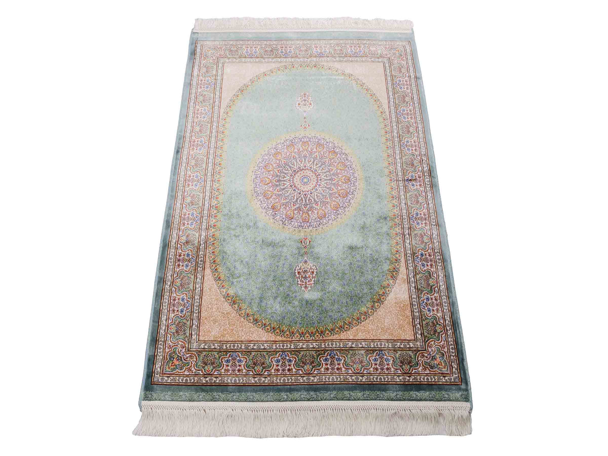 Ghom Maschinenteppich "Fereydun" 120 x 80 cm aus pflanzlicher Seide (Viskose) mit Medaillon, Türkis. Teppichnummer: V28TL096M. Persian Luxury Collection by Khademi. Made in Iran / Persia – Vertrieb durch JUPITER Intl.