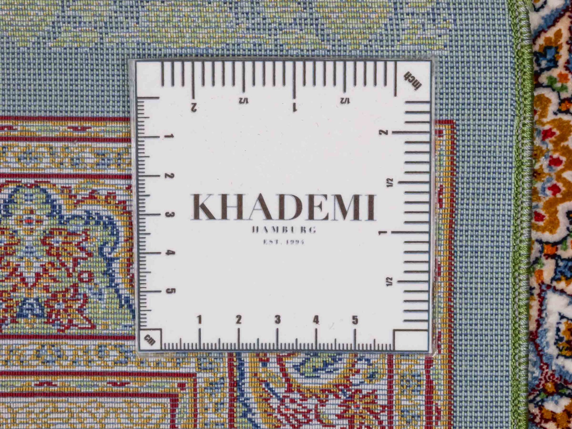 Ghom Maschinenteppich "Fereydun" 90 x 60 cm aus pflanzlicher Seide (Viskose) mit Medaillon, Türkis. Teppichnummer: V28TL054M. Persian Luxury Collection by Khademi. Made in Iran / Persia – Vertrieb durch JUPITER Intl.