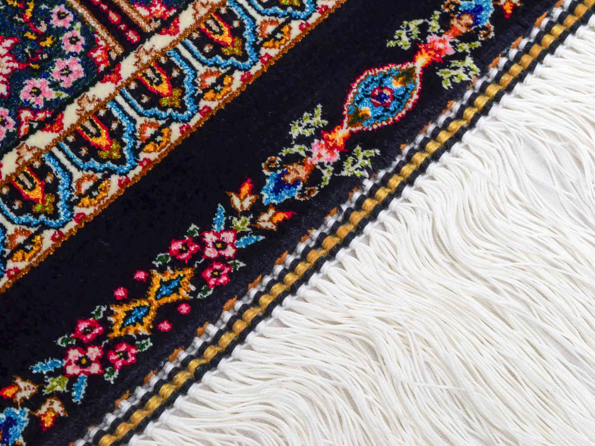 Ghom Maschinenteppich "Goshasp" 150 x 100 cm, mit Medaillon, aus pflanzlicher Seide (Viskose), Schwarz-Grün-Mehrfarbig. Teppichnummer: V40BK150H. Persian Luxury Collection by Khademi. Made in Iran / Persia – Vertrieb durch JUPITER Intl.