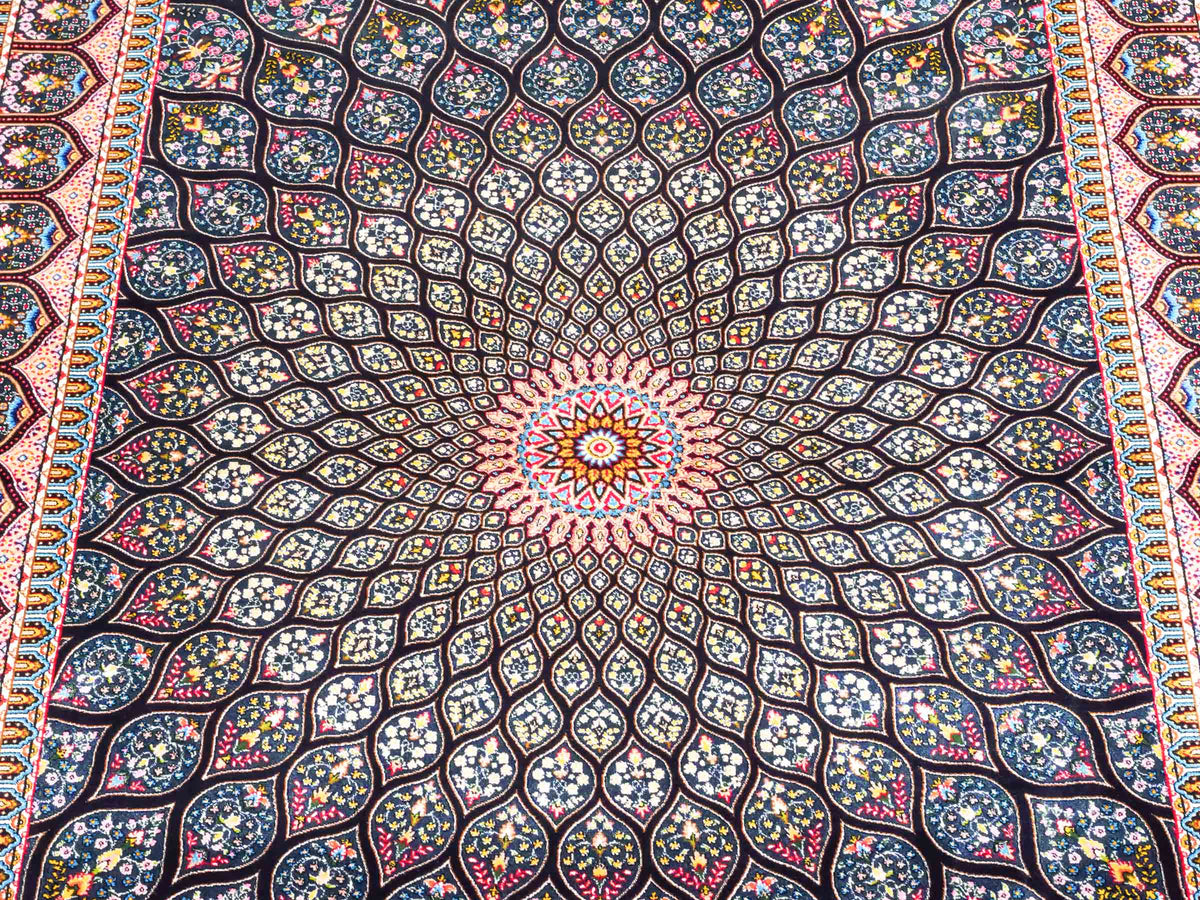 Ghom Maschinenteppich "Goshasp" 150 x 100 cm, mit Medaillon, aus pflanzlicher Seide (Viskose), Schwarz-Grün-Mehrfarbig. Teppichnummer: V40BK150H. Persian Luxury Collection by Khademi. Made in Iran / Persia – Vertrieb durch JUPITER Intl.
