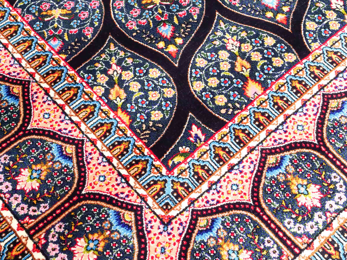 Ghom Maschinenteppich "Goshasp" 150 x 100 cm, mit Medaillon, aus pflanzlicher Seide (Viskose), Schwarz-Grün-Mehrfarbig. Teppichnummer: V40BK150H. Persian Luxury Collection by Khademi. Made in Iran / Persia – Vertrieb durch JUPITER Intl.