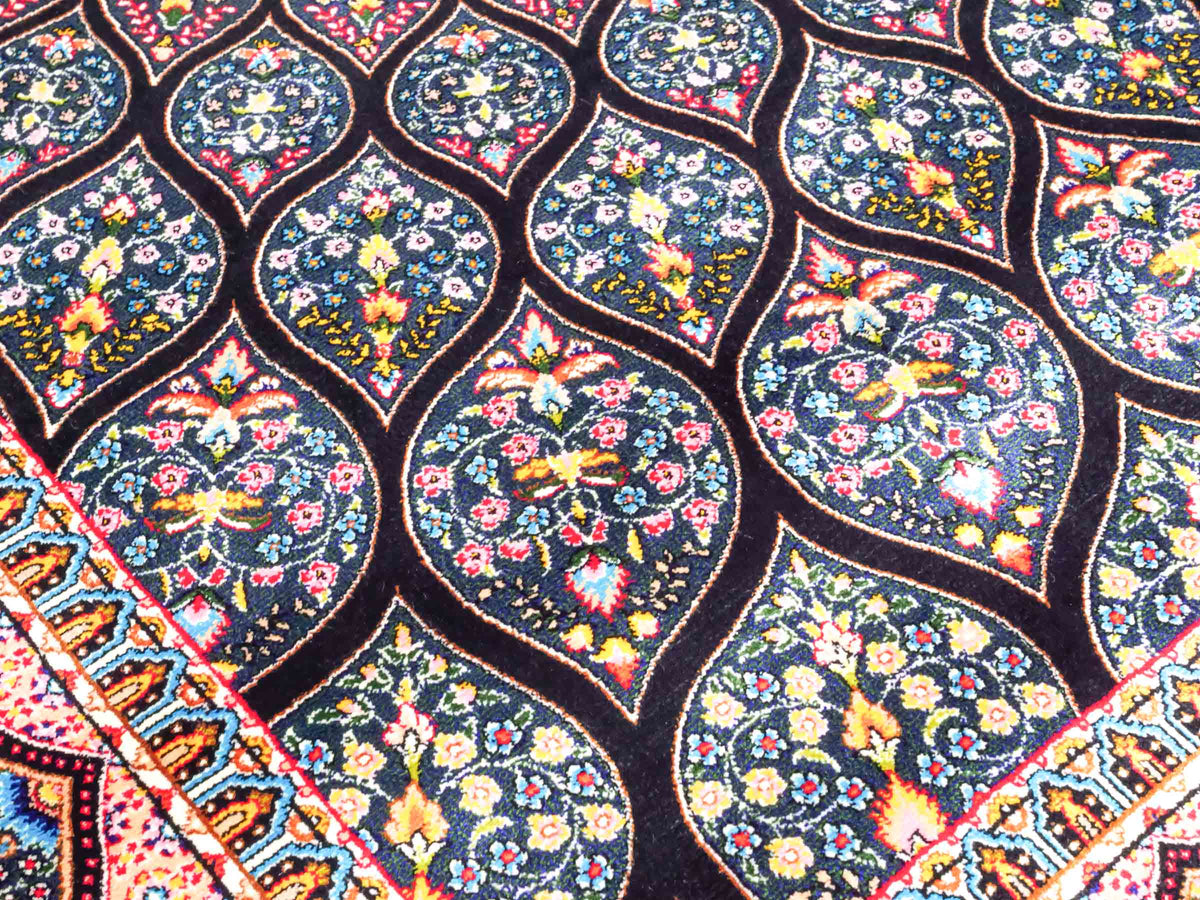 Ghom Maschinenteppich "Goshasp" 150 x 100 cm, mit Medaillon, aus pflanzlicher Seide (Viskose), Schwarz-Grün-Mehrfarbig. Teppichnummer: V40BK150H. Persian Luxury Collection by Khademi. Made in Iran / Persia – Vertrieb durch JUPITER Intl.