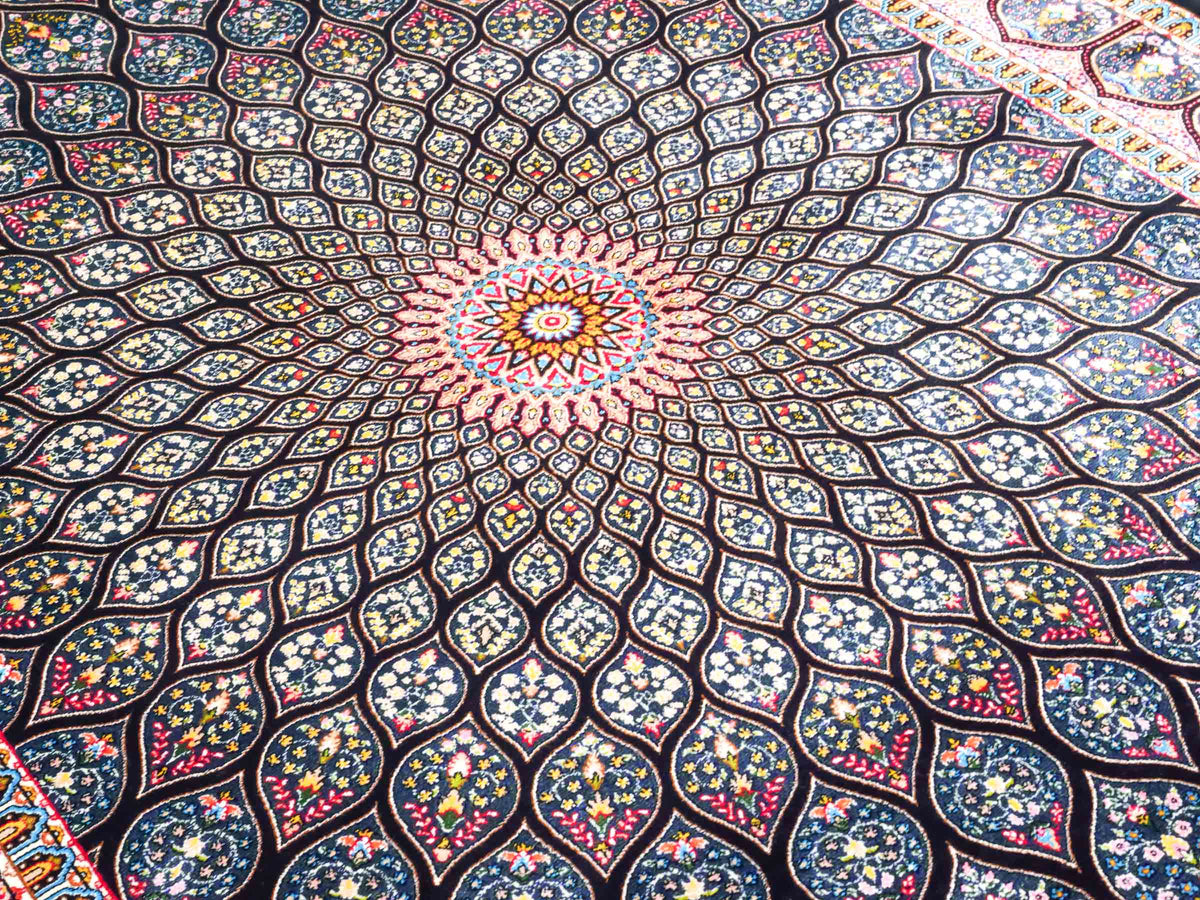 Ghom Maschinenteppich "Goshasp" 150 x 100 cm, mit Medaillon, aus pflanzlicher Seide (Viskose), Schwarz-Grün-Mehrfarbig. Teppichnummer: V40BK150H. Persian Luxury Collection by Khademi. Made in Iran / Persia – Vertrieb durch JUPITER Intl.