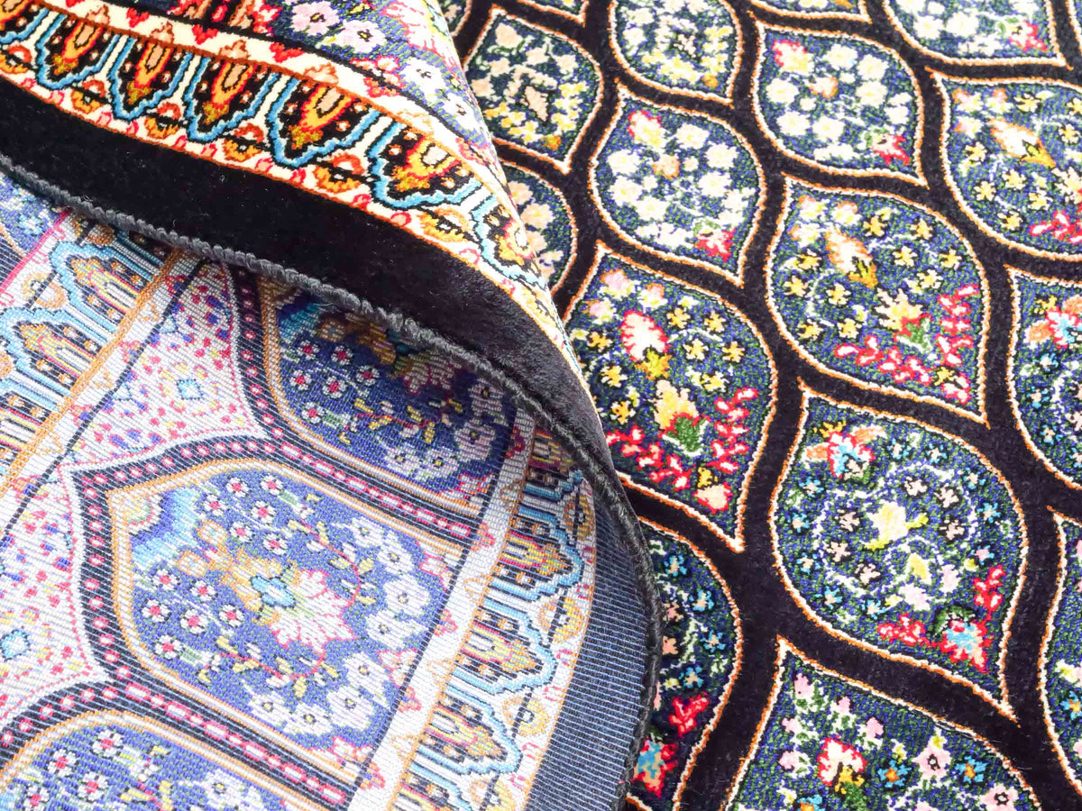 Ghom Maschinenteppich "Goshasp" 150 x 100 cm, mit Medaillon, aus pflanzlicher Seide (Viskose), Schwarz-Grün-Mehrfarbig. Teppichnummer: V40BK150H. Persian Luxury Collection by Khademi. Made in Iran / Persia – Vertrieb durch JUPITER Intl.