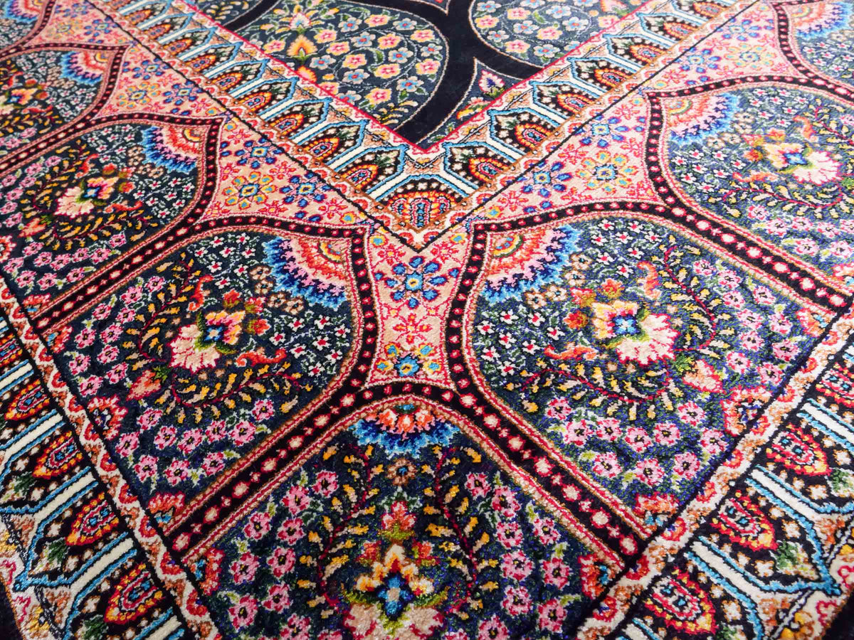 Ghom Maschinenteppich "Goshasp" 225 x 150 cm, mit Medaillon, aus pflanzlicher Seide (Viskose), Schwarz-Grün-Mehrfarbig. Teppichnummer: V40BK338H. Persian Luxury Collection by Khademi. Made in Iran / Persia – Vertrieb durch JUPITER Intl.