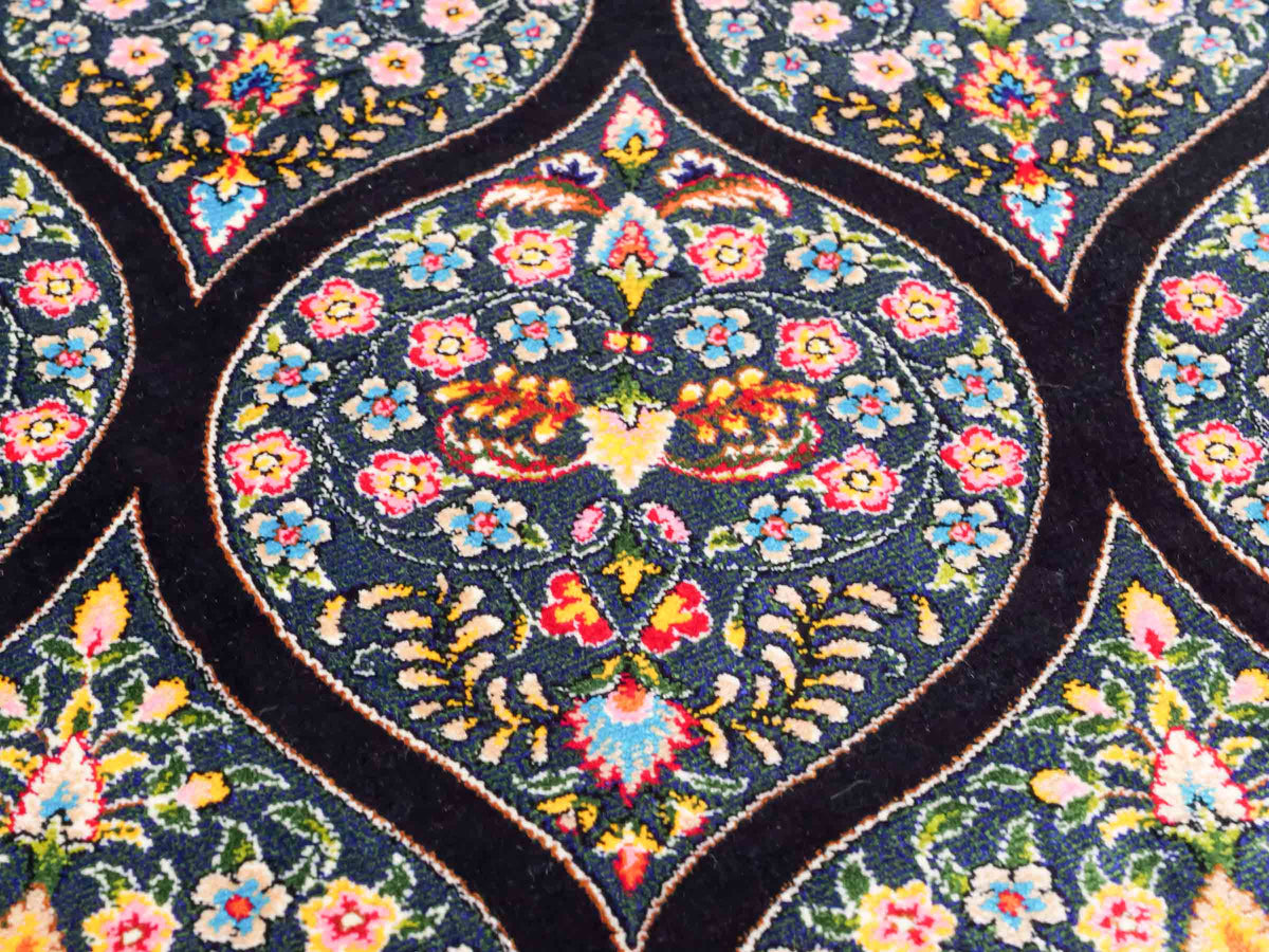 Ghom Maschinenteppich "Goshasp" 225 x 150 cm, mit Medaillon, aus pflanzlicher Seide (Viskose), Schwarz-Grün-Mehrfarbig. Teppichnummer: V40BK338H. Persian Luxury Collection by Khademi. Made in Iran / Persia – Vertrieb durch JUPITER Intl.