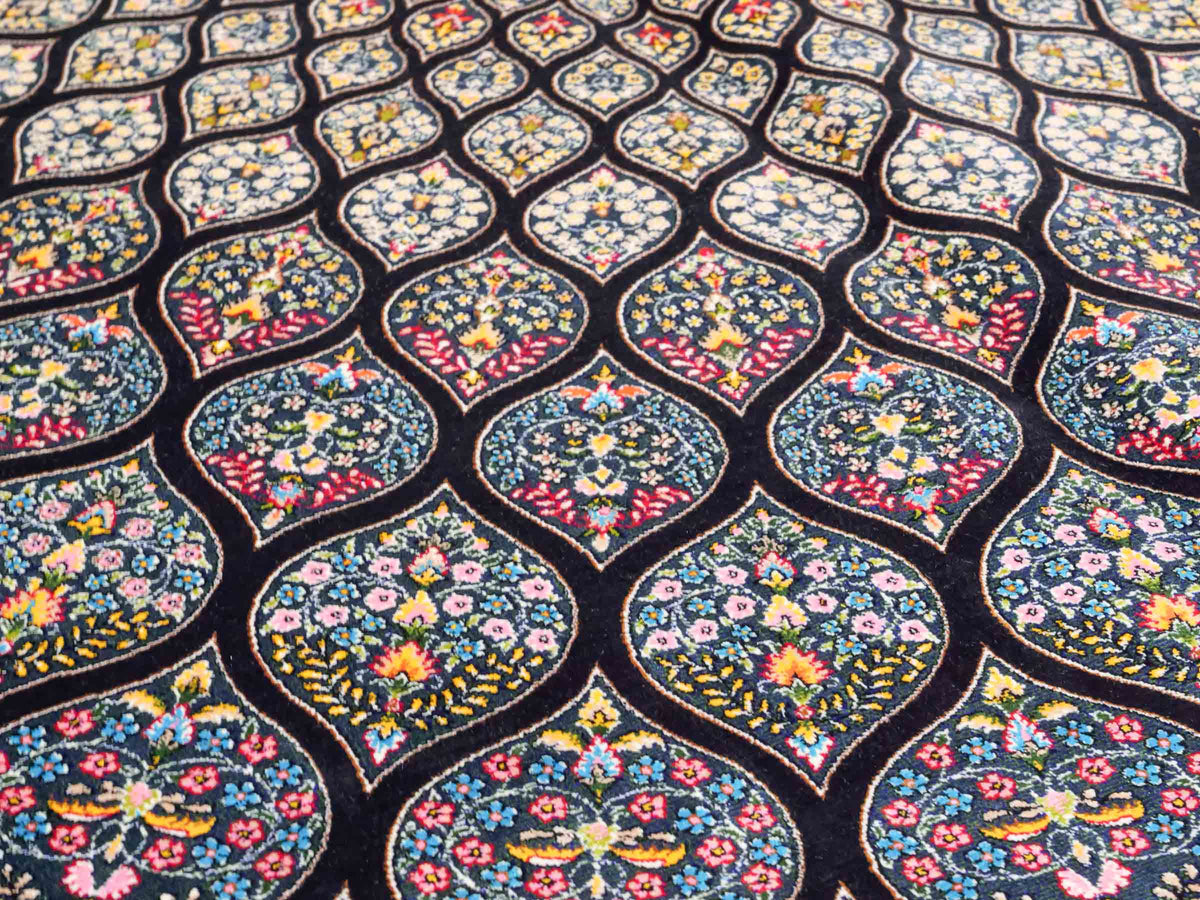 Ghom Maschinenteppich "Goshasp" 225 x 150 cm, mit Medaillon, aus pflanzlicher Seide (Viskose), Schwarz-Grün-Mehrfarbig. Teppichnummer: V40BK338H. Persian Luxury Collection by Khademi. Made in Iran / Persia – Vertrieb durch JUPITER Intl.