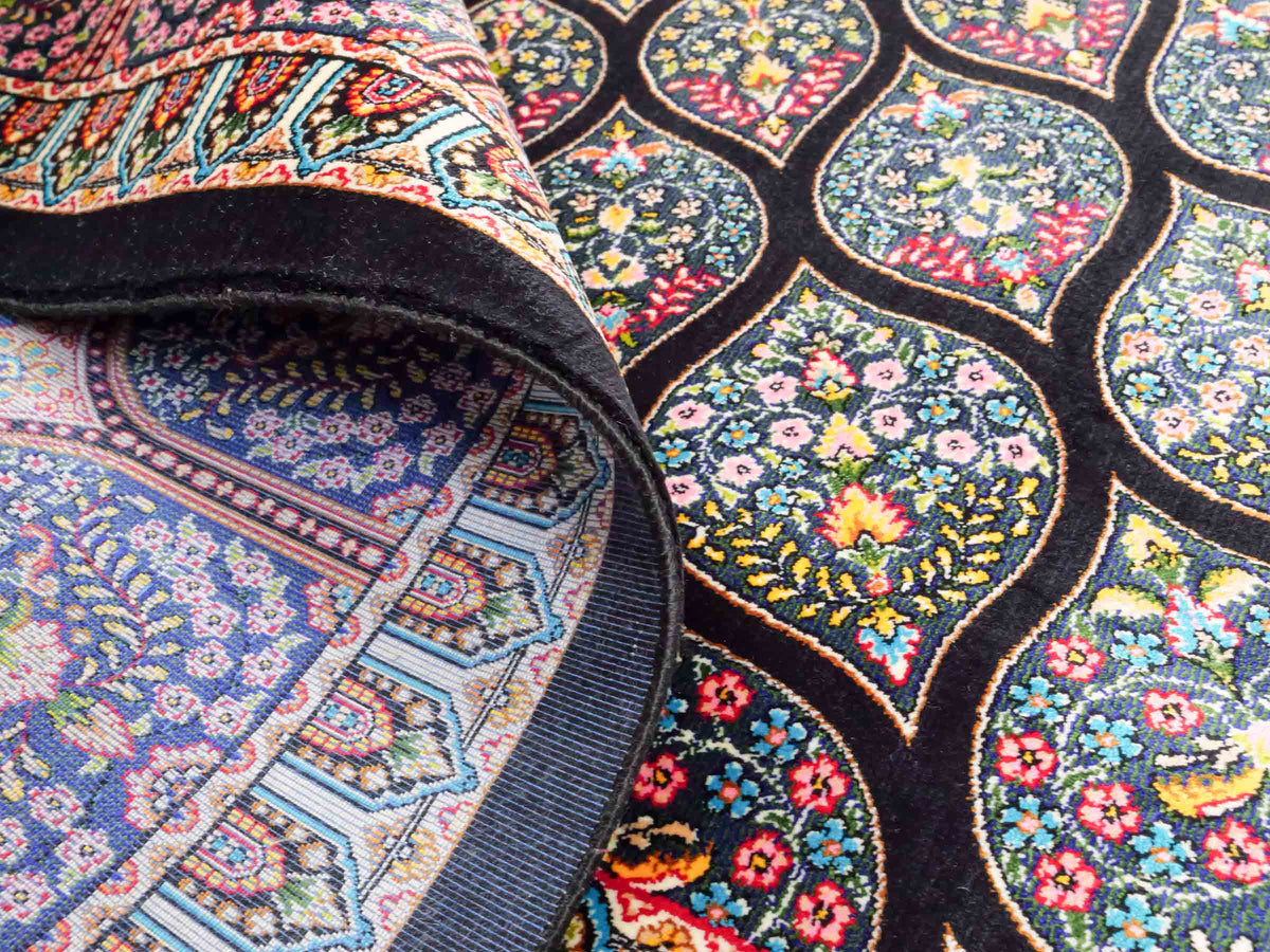 Ghom Maschinenteppich "Goshasp" 225 x 150 cm, mit Medaillon, aus pflanzlicher Seide (Viskose), Schwarz-Grün-Mehrfarbig. Teppichnummer: V40BK338H. Persian Luxury Collection by Khademi. Made in Iran / Persia – Vertrieb durch JUPITER Intl.