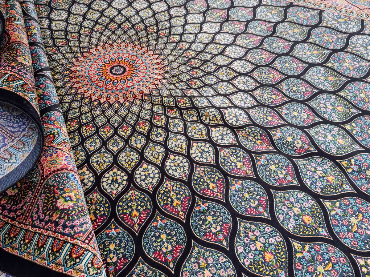 Ghom Maschinenteppich "Goshasp" 225 x 150 cm, mit Medaillon, aus pflanzlicher Seide (Viskose), Schwarz-Grün-Mehrfarbig. Teppichnummer: V40BK338H. Persian Luxury Collection by Khademi. Made in Iran / Persia – Vertrieb durch JUPITER Intl.