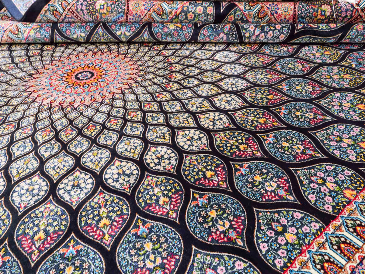 Ghom Maschinenteppich "Goshasp" 225 x 150 cm, mit Medaillon, aus pflanzlicher Seide (Viskose), Schwarz-Grün-Mehrfarbig. Teppichnummer: V40BK338H. Persian Luxury Collection by Khademi. Made in Iran / Persia – Vertrieb durch JUPITER Intl.