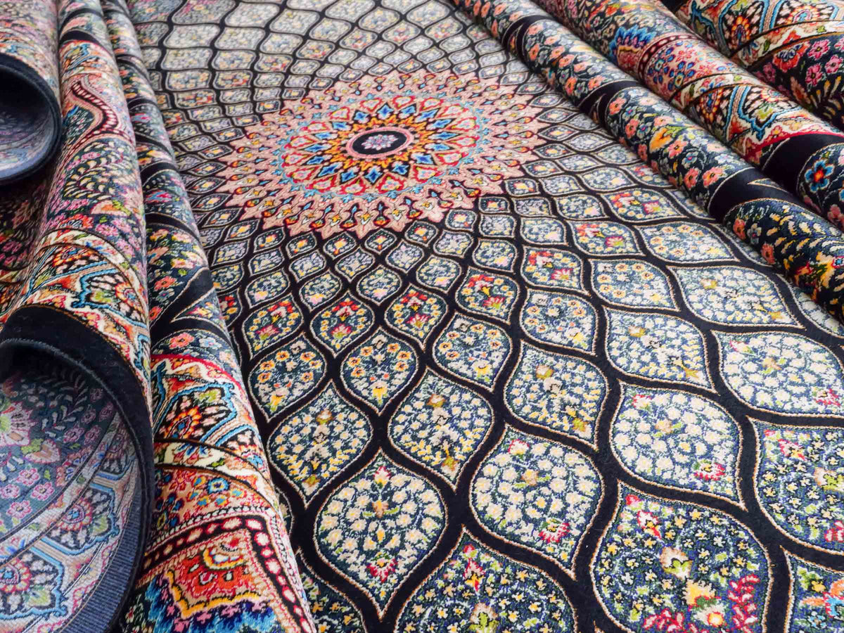Ghom Maschinenteppich "Goshasp" 300 x 200 cm, mit Medaillon, aus pflanzlicher Seide (Viskose), Schwarz-Grün-Mehrfarbig. Teppichnummer: V40BK600H. Persian Luxury Collection by Khademi. Made in Iran / Persia – Vertrieb durch JUPITER Intl.