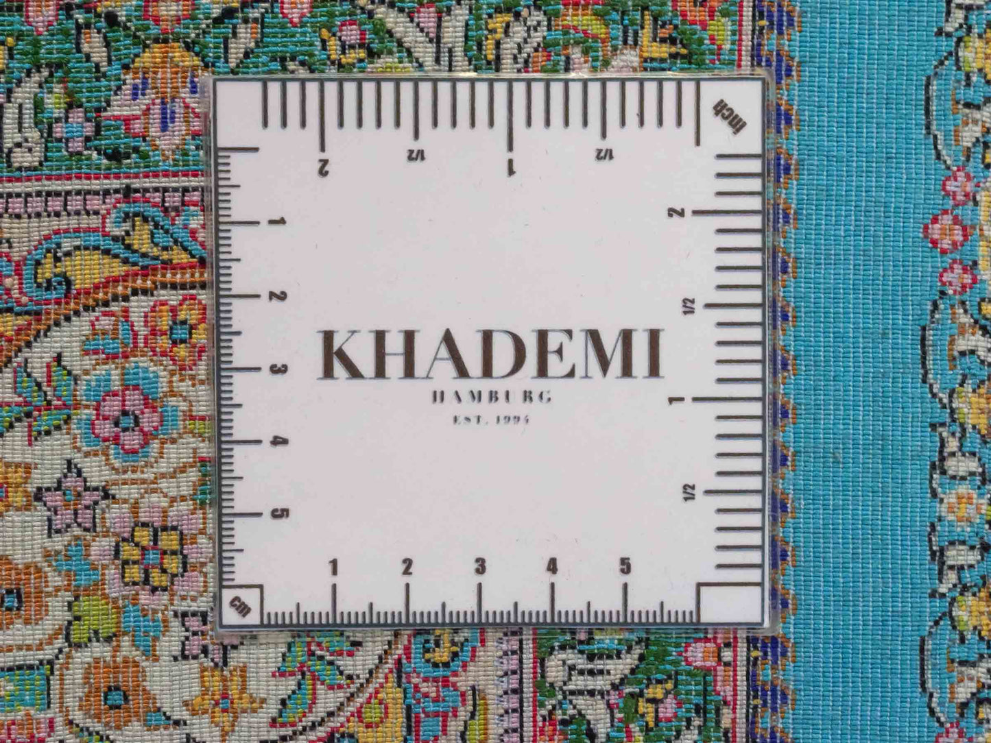 Ghom Maschinenteppich "Homay" 150 x 100 cm aus pflanzlicher Seide (Viskose) mit Medaillon, Hellblau, Hellgrün. Teppichnummer: V45TG150H. Persian Luxury Collection by Khademi. Made in Iran / Persia – Vertrieb durch JUPITER Intl.