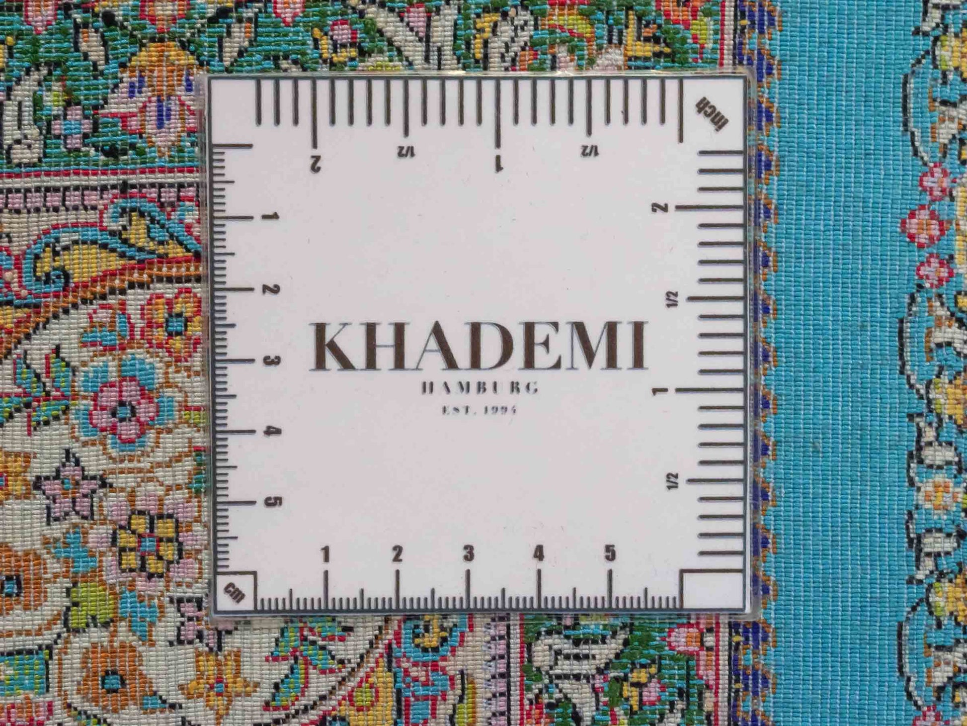 Ghom Maschinenteppich "Homay" 150 x 100 cm aus pflanzlicher Seide (Viskose) mit Medaillon, Hellblau, Hellgrün. Teppichnummer: V45TG150H. Persian Luxury Collection by Khademi. Made in Iran / Persia – Vertrieb durch JUPITER Intl.