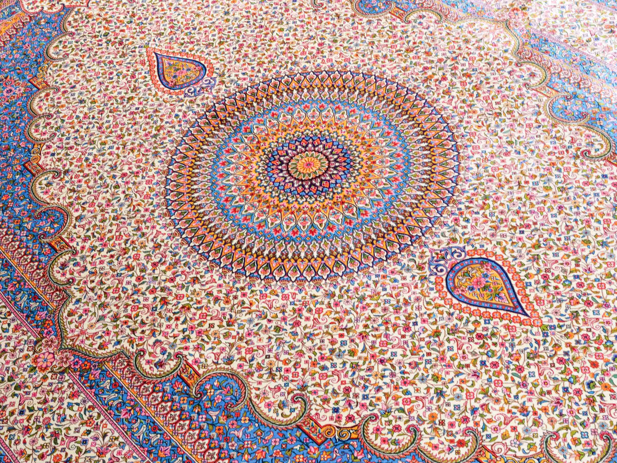 Ghom Maschinenteppich "Homay" 225 x 150 cm, mit Medaillon, aus pflanzlicher Seide (Viskose), Cremeweiß/Hellblau. Teppichnummer: V45CT338H. Persian Luxury Collection by Khademi. Made in Iran / Persia – Vertrieb durch JUPITER Intl.