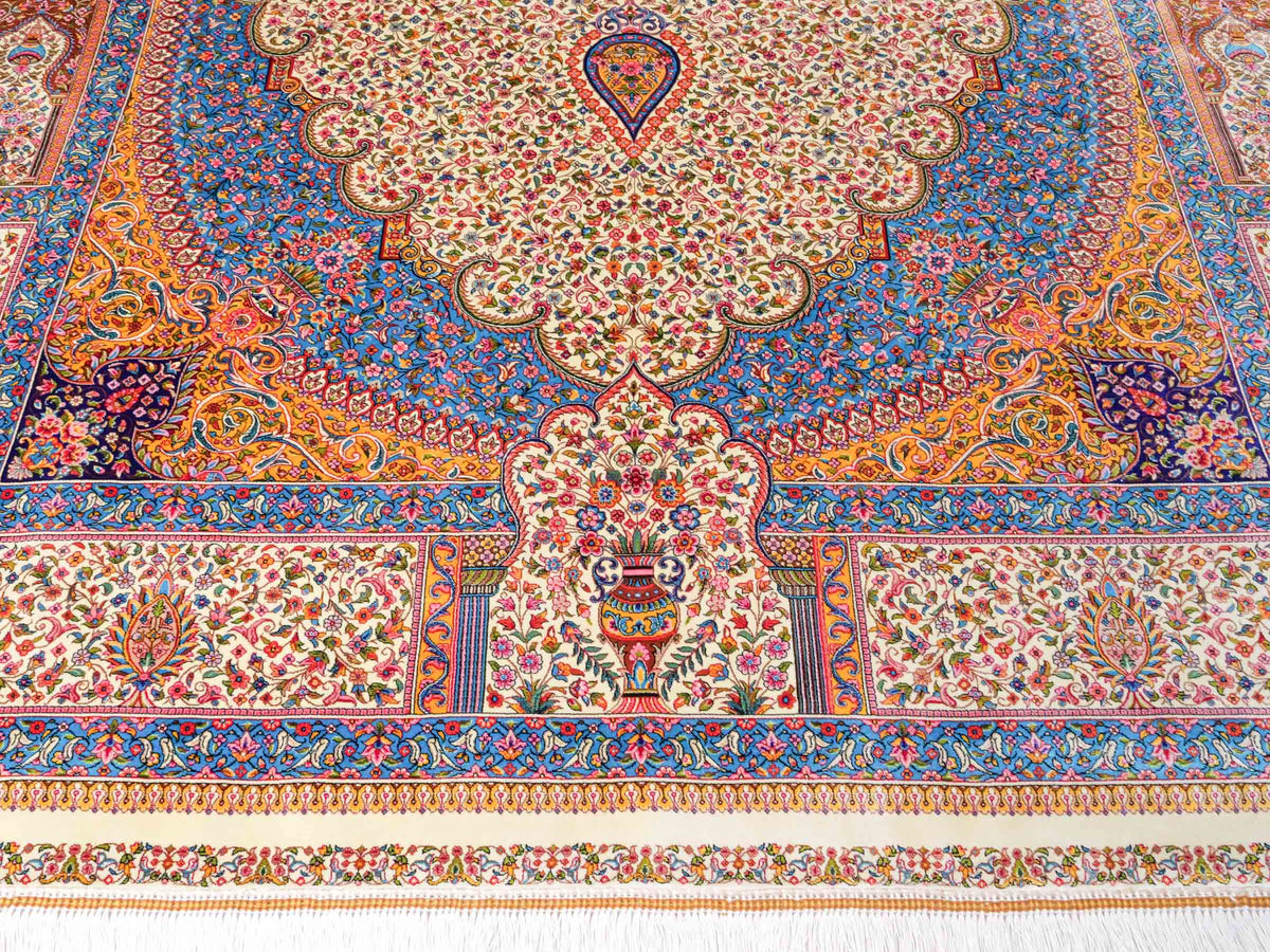 Ghom Maschinenteppich "Homay" 225 x 150 cm, mit Medaillon, aus pflanzlicher Seide (Viskose), Cremeweiß/Hellblau. Teppichnummer: V45CT338H. Persian Luxury Collection by Khademi. Made in Iran / Persia – Vertrieb durch JUPITER Intl.