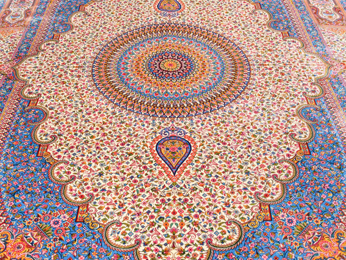 Ghom Maschinenteppich "Homay" 225 x 150 cm, mit Medaillon, aus pflanzlicher Seide (Viskose), Cremeweiß/Hellblau. Teppichnummer: V45CT338H. Persian Luxury Collection by Khademi. Made in Iran / Persia – Vertrieb durch JUPITER Intl.