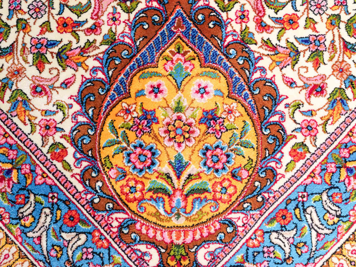 Ghom Maschinenteppich "Homay" 225 x 150 cm, mit Medaillon, aus pflanzlicher Seide (Viskose), Cremeweiß/Hellblau. Teppichnummer: V45CT338H. Persian Luxury Collection by Khademi. Made in Iran / Persia – Vertrieb durch JUPITER Intl.