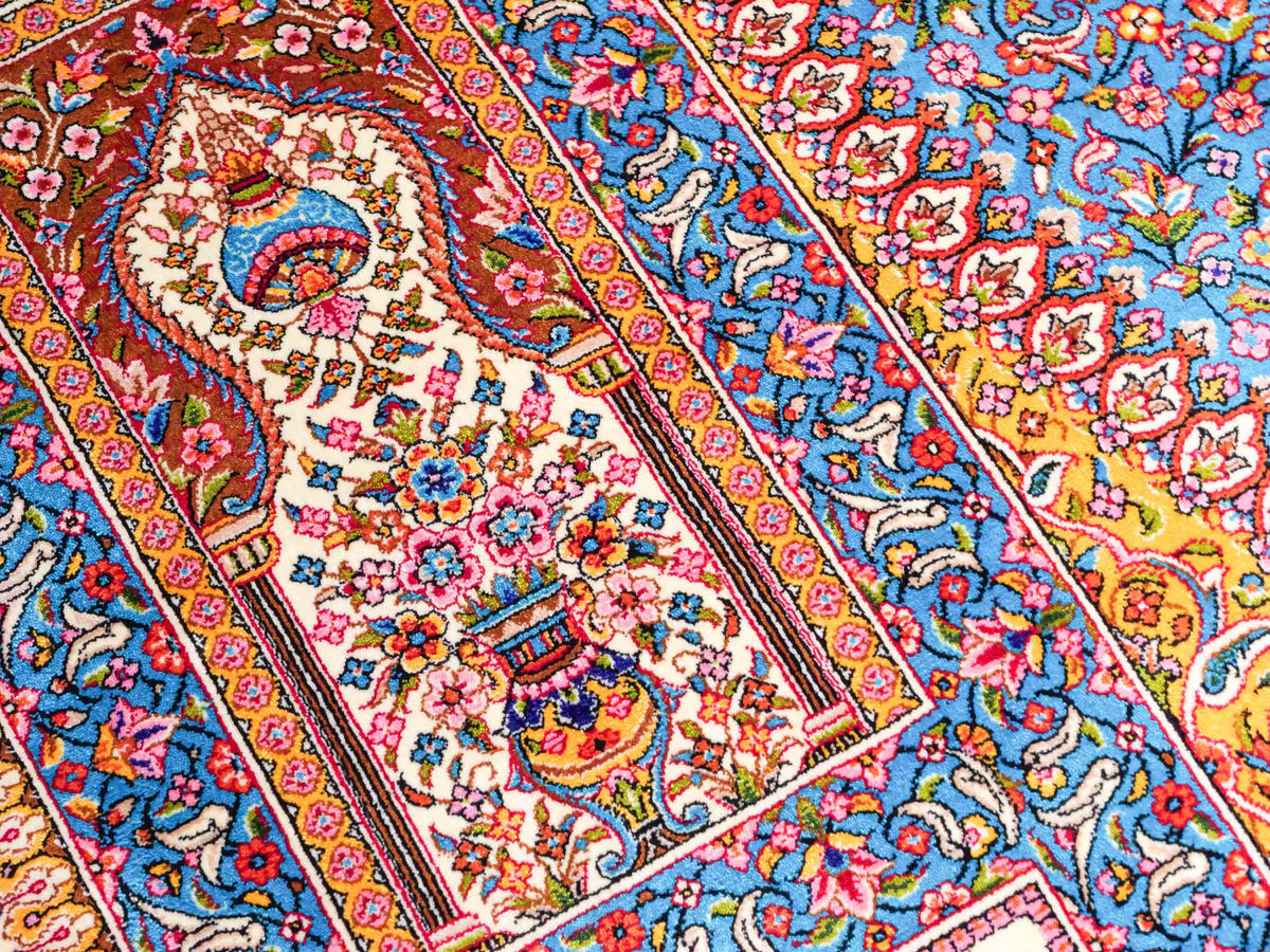 Ghom Maschinenteppich "Homay" 225 x 150 cm, mit Medaillon, aus pflanzlicher Seide (Viskose), Cremeweiß/Hellblau. Teppichnummer: V45CT338H. Persian Luxury Collection by Khademi. Made in Iran / Persia – Vertrieb durch JUPITER Intl.