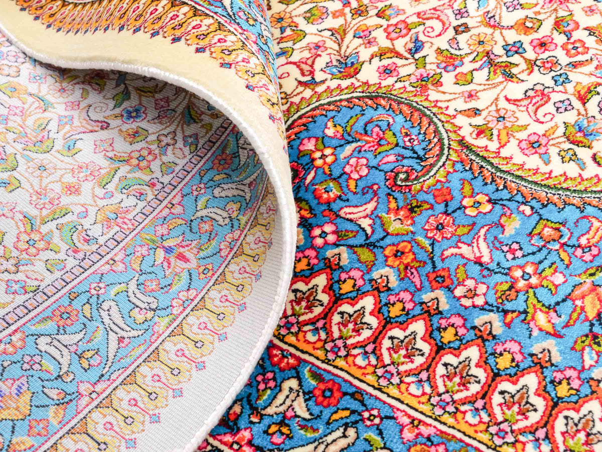 Ghom Maschinenteppich "Homay" 225 x 150 cm, mit Medaillon, aus pflanzlicher Seide (Viskose), Cremeweiß/Hellblau. Teppichnummer: V45CT338H. Persian Luxury Collection by Khademi. Made in Iran / Persia – Vertrieb durch JUPITER Intl.