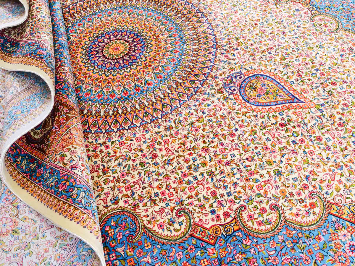 Ghom Maschinenteppich "Homay" 225 x 150 cm, mit Medaillon, aus pflanzlicher Seide (Viskose), Cremeweiß/Hellblau. Teppichnummer: V45CT338H. Persian Luxury Collection by Khademi. Made in Iran / Persia – Vertrieb durch JUPITER Intl.