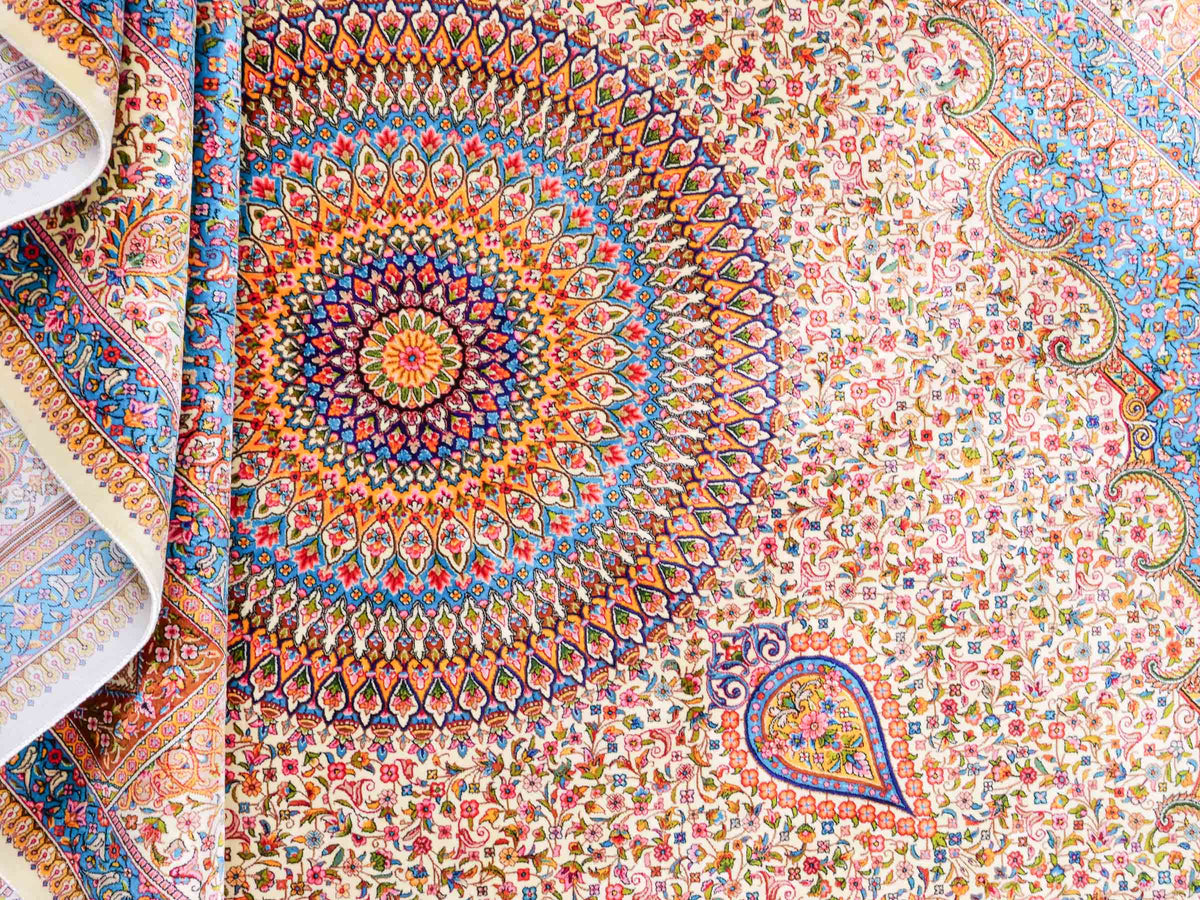 Ghom Maschinenteppich "Homay" 225 x 150 cm, mit Medaillon, aus pflanzlicher Seide (Viskose), Cremeweiß/Hellblau. Teppichnummer: V45CT338H. Persian Luxury Collection by Khademi. Made in Iran / Persia – Vertrieb durch JUPITER Intl.
