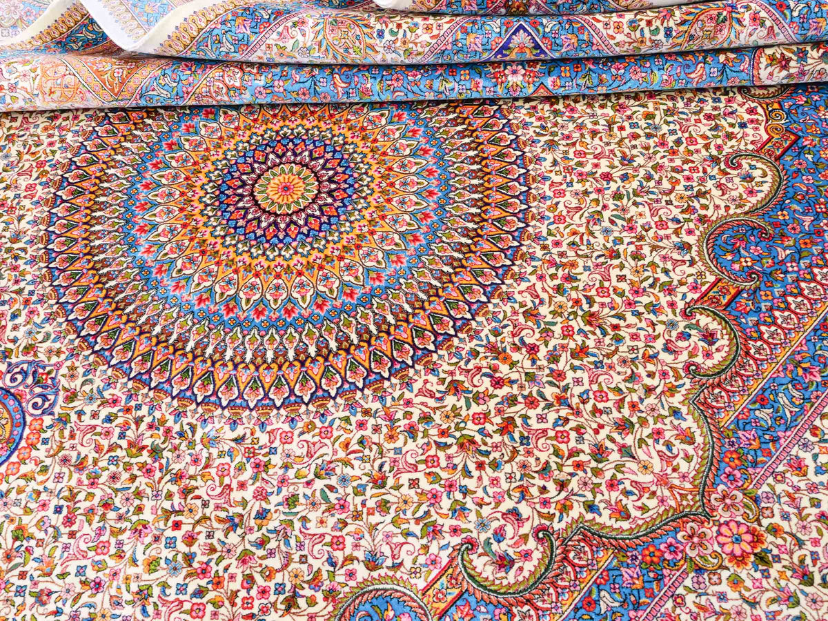 Ghom Maschinenteppich "Homay" 225 x 150 cm, mit Medaillon, aus pflanzlicher Seide (Viskose), Cremeweiß/Hellblau. Teppichnummer: V45CT338H. Persian Luxury Collection by Khademi. Made in Iran / Persia – Vertrieb durch JUPITER Intl.