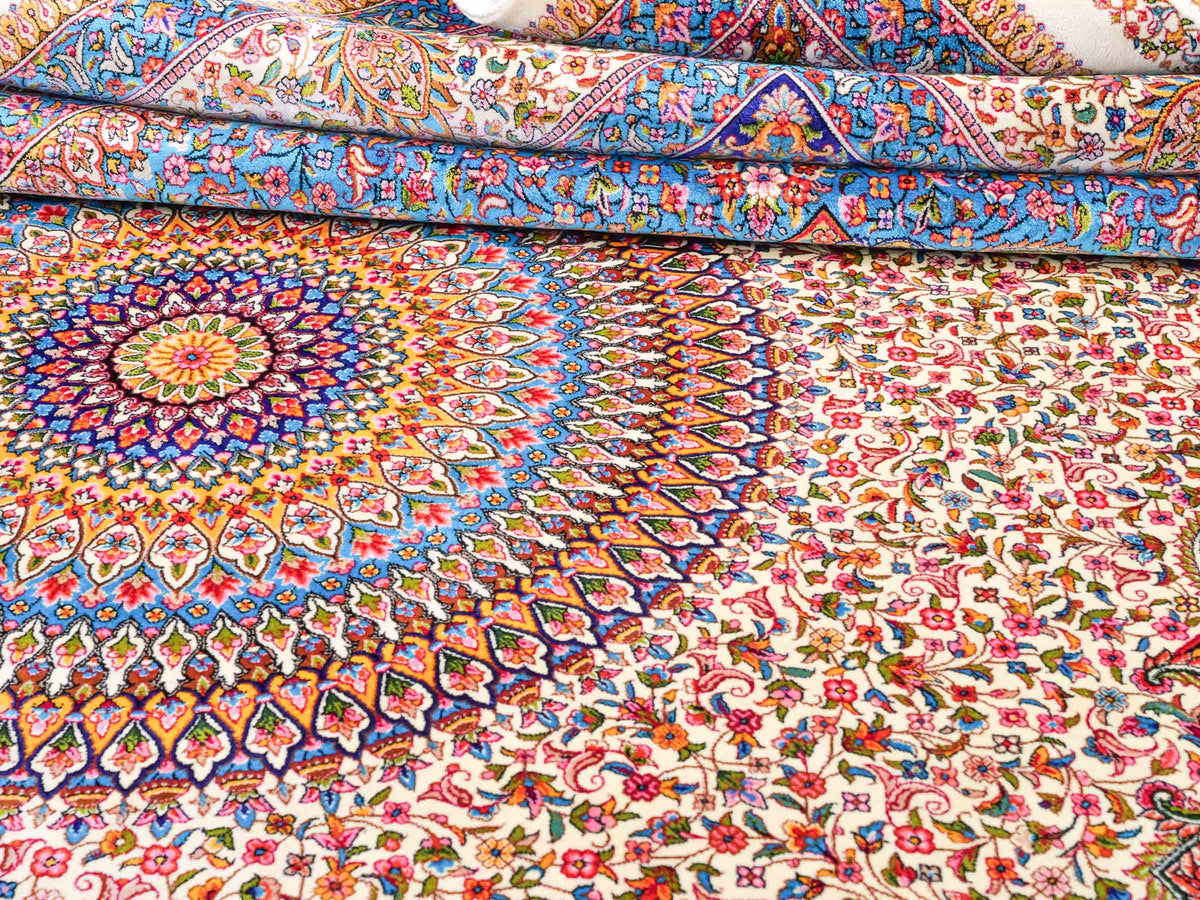 Ghom Maschinenteppich "Homay" 225 x 150 cm, mit Medaillon, aus pflanzlicher Seide (Viskose), Cremeweiß/Hellblau. Teppichnummer: V45CT338H. Persian Luxury Collection by Khademi. Made in Iran / Persia – Vertrieb durch JUPITER Intl.