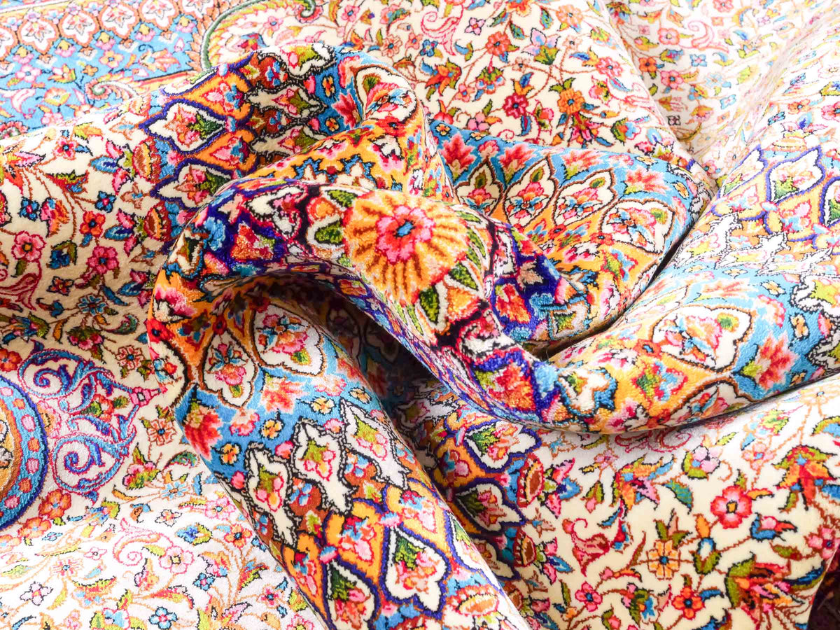 Ghom Maschinenteppich "Homay" 225 x 150 cm, mit Medaillon, aus pflanzlicher Seide (Viskose), Cremeweiß/Hellblau. Teppichnummer: V45CT338H. Persian Luxury Collection by Khademi. Made in Iran / Persia – Vertrieb durch JUPITER Intl.