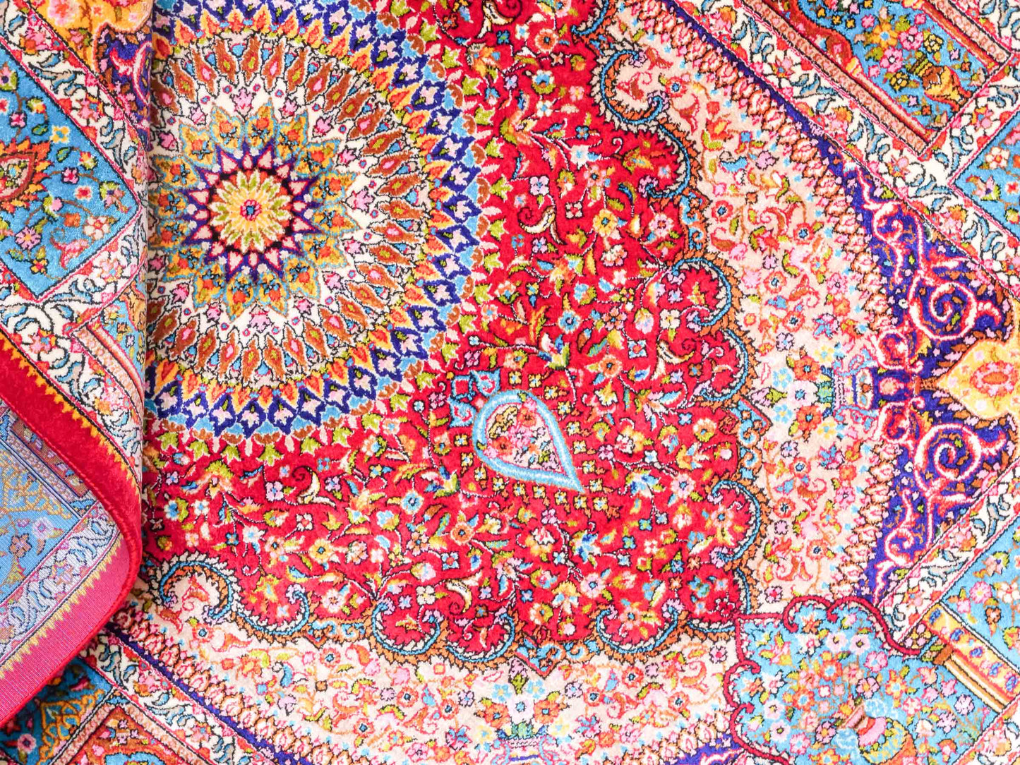 Ghom Maschinenteppich "Homay" 90 x 60 cm aus pflanzlicher Seide (Viskose) mit Medaillon, Rot, Hellblau. Teppichnummer: V45RD054H. Persian Luxury Collection by Khademi. Made in Iran / Persia – Vertrieb durch JUPITER Intl.